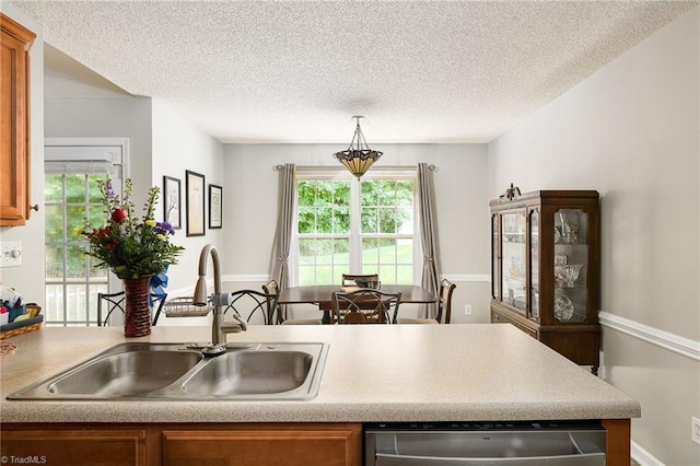 3714 Courtland Cir, Thomasville, NC 27360 - kitchen with stainless steel dishwasher, brown cabinets, healthy amount of natural light, light countertops, and a textured ceiling