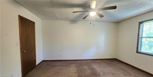 carpeted empty room with ceiling fan, a textured ceiling, and baseboards