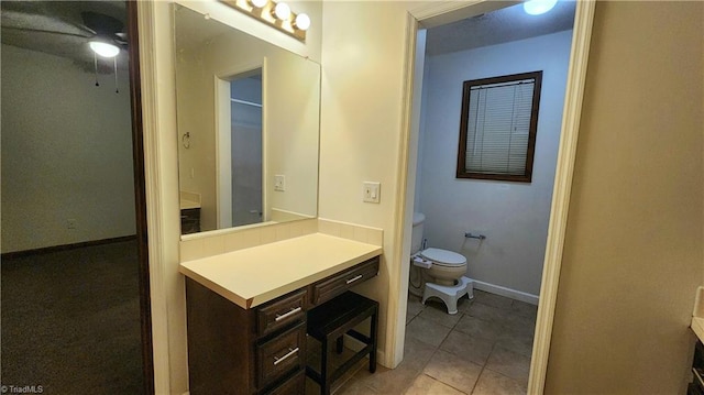 bathroom featuring vanity, toilet, baseboards, and tile patterned flooring