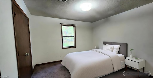 bedroom with carpet, baseboards, and a textured ceiling