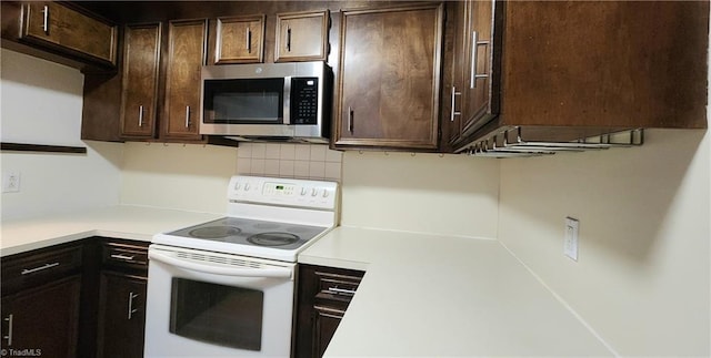 kitchen with stainless steel microwave, light countertops, dark brown cabinetry, and white range with electric cooktop