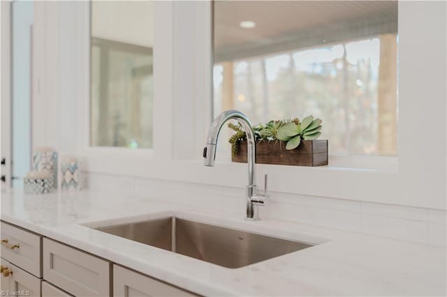 interior details with white cabinetry and sink