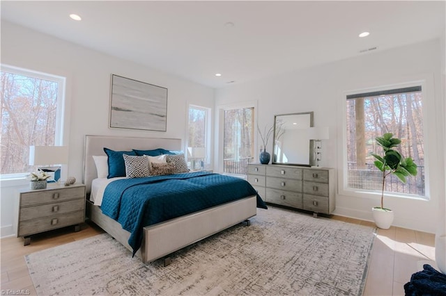 bedroom featuring multiple windows and light hardwood / wood-style floors