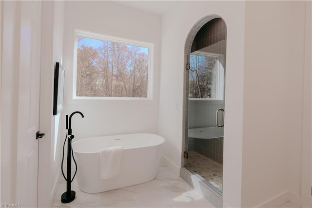 bathroom featuring plenty of natural light and shower with separate bathtub