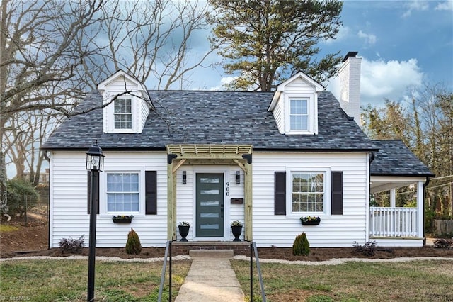 cape cod home featuring a front lawn