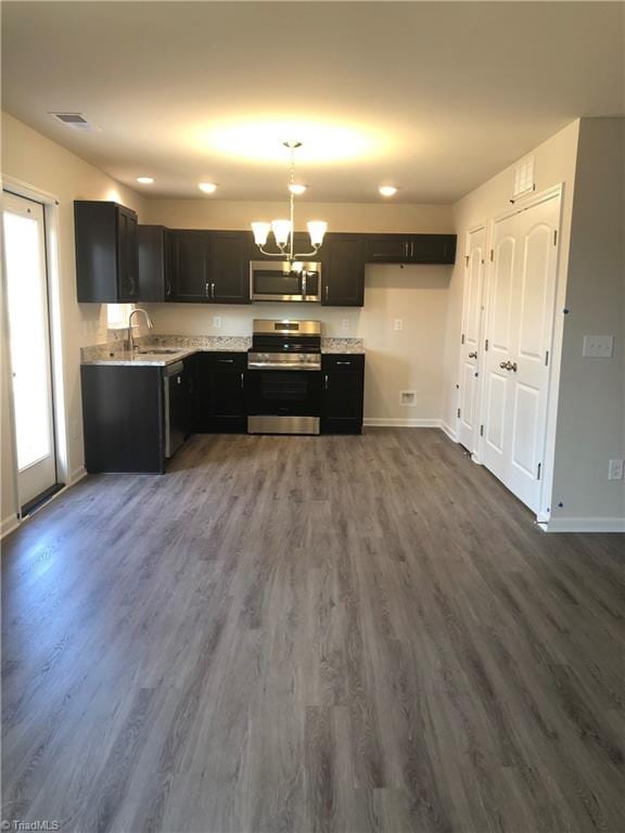 kitchen featuring dark wood-style flooring, a notable chandelier, visible vents, appliances with stainless steel finishes, and baseboards