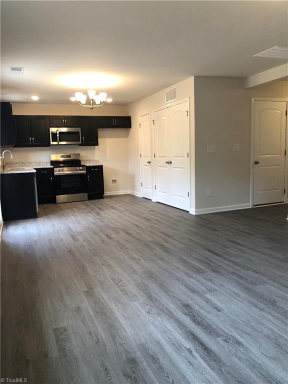 kitchen with stainless steel appliances, light countertops, visible vents, a chandelier, and baseboards