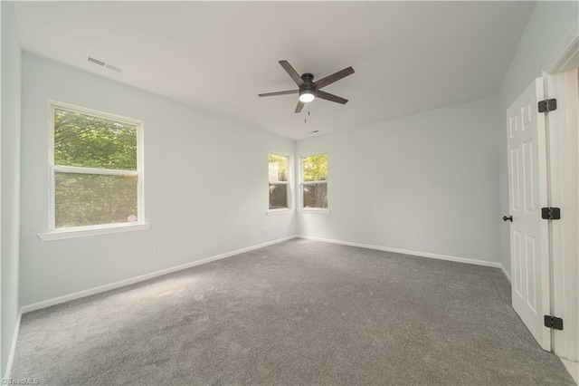 carpeted spare room with a ceiling fan, baseboards, and visible vents