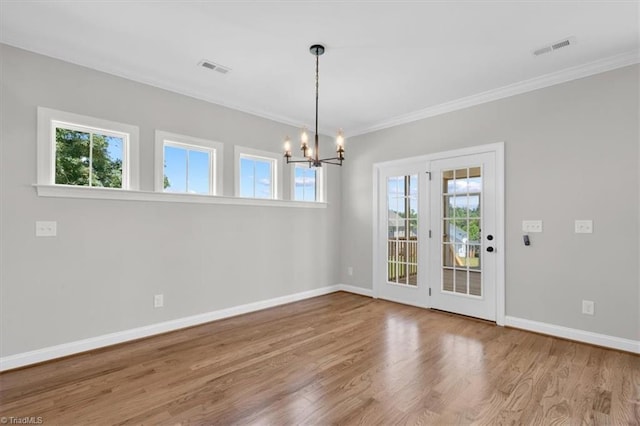 unfurnished dining area with crown molding, a notable chandelier, visible vents, wood finished floors, and baseboards