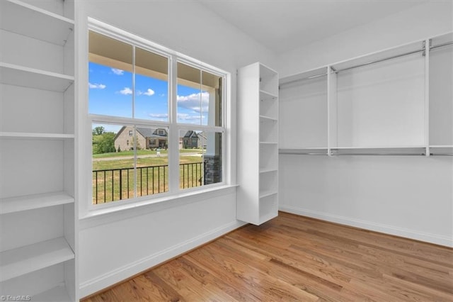 walk in closet with wood finished floors