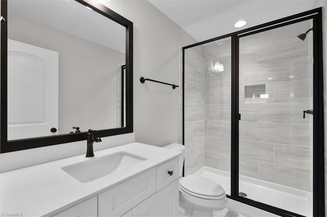 bathroom featuring a stall shower, vanity, toilet, and recessed lighting