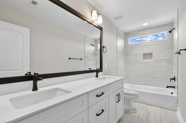 full bath featuring toilet, a sink, and visible vents