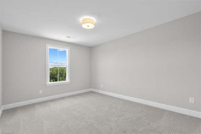 carpeted empty room with visible vents and baseboards