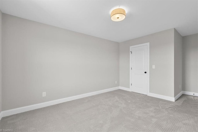 carpeted empty room featuring baseboards