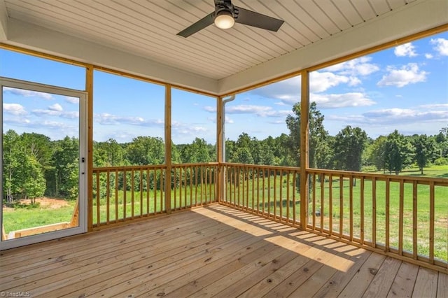 unfurnished sunroom featuring ceiling fan and a wealth of natural light