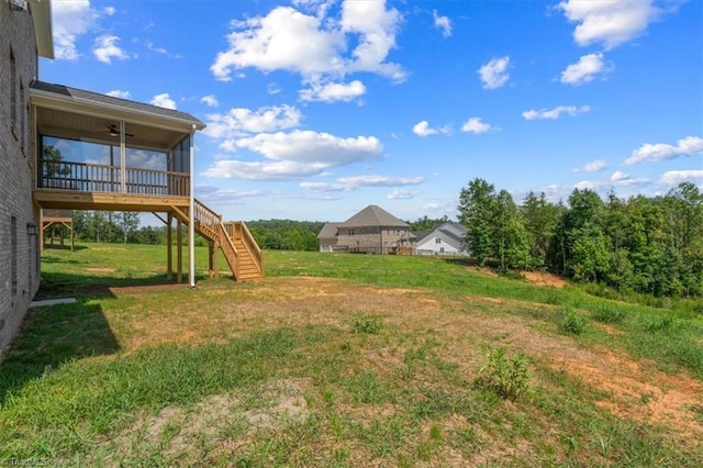 view of yard featuring stairs, ceiling fan, and a sunroom