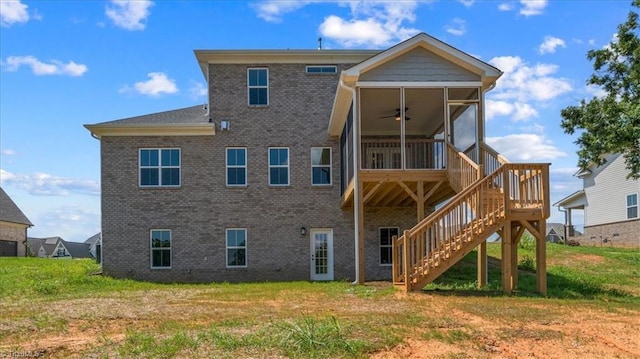 back of property with a ceiling fan, a sunroom, brick siding, and stairway