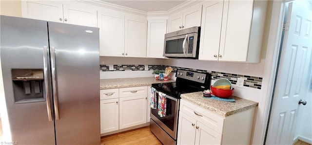 kitchen featuring light hardwood / wood-style flooring, white cabinetry, backsplash, stainless steel appliances, and light stone countertops