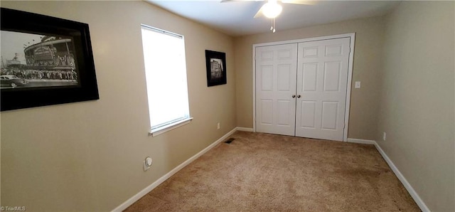 unfurnished bedroom with light colored carpet, ceiling fan, and a closet