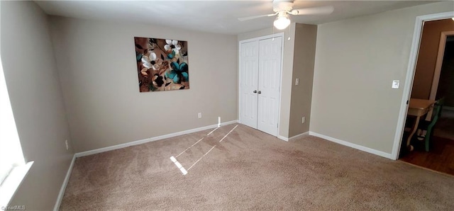 unfurnished bedroom with ceiling fan, carpet flooring, and a closet