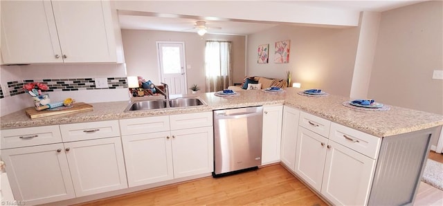 kitchen featuring white cabinetry, stainless steel dishwasher, kitchen peninsula, and sink