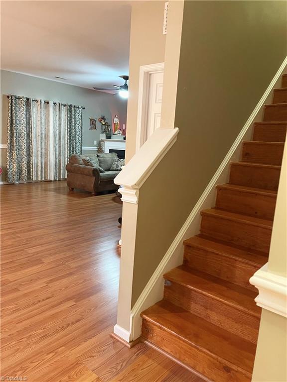 stairs with ceiling fan and hardwood / wood-style floors