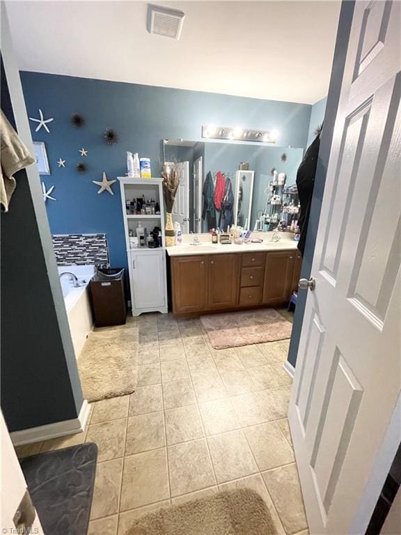 bathroom featuring a washtub, vanity, and tile patterned floors