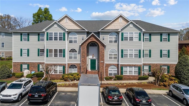 multi unit property with brick siding and uncovered parking
