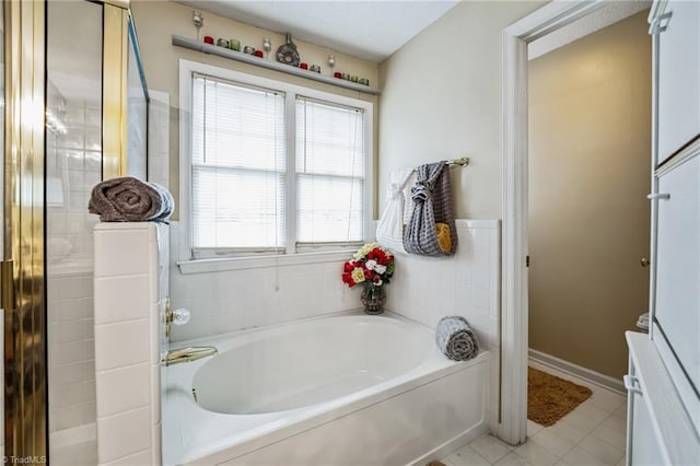 bathroom featuring tile patterned flooring, plenty of natural light, and a tub to relax in