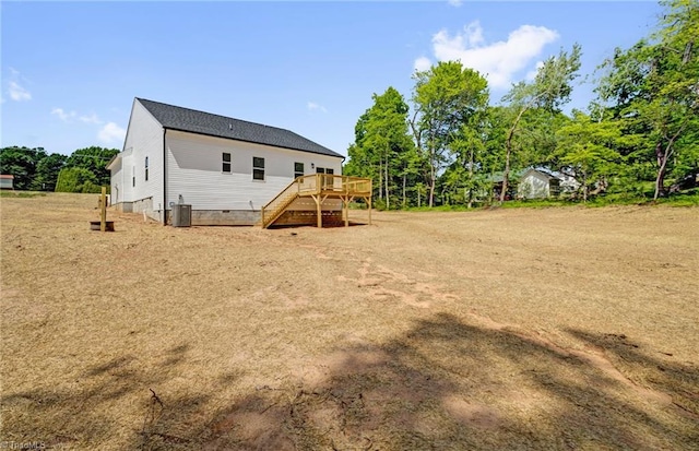 rear view of property with a wooden deck, cooling unit, stairway, and crawl space