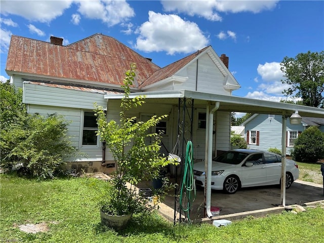 705 Washington St, Graham, NC 27253 - view of home's exterior featuring a chimney, an attached carport, and metal roof