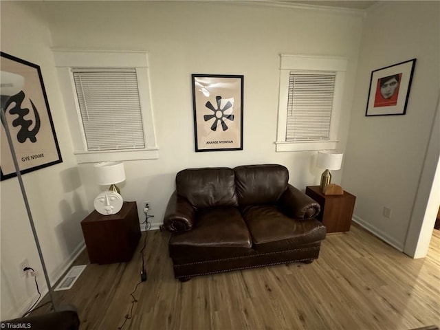 living room featuring wood-type flooring and ornamental molding