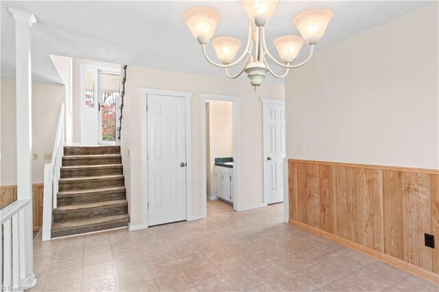 unfurnished room with wood walls and a notable chandelier