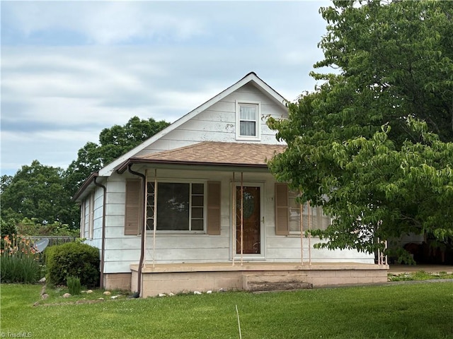 223 Flint Hill Rd, North Wilkesboro, NC 28659 - view of front facade featuring covered porch, roof with shingles, and a front lawn