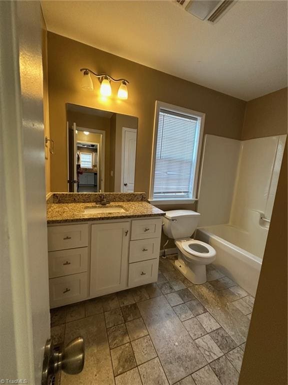 full bathroom featuring vanity, washtub / shower combination, and toilet