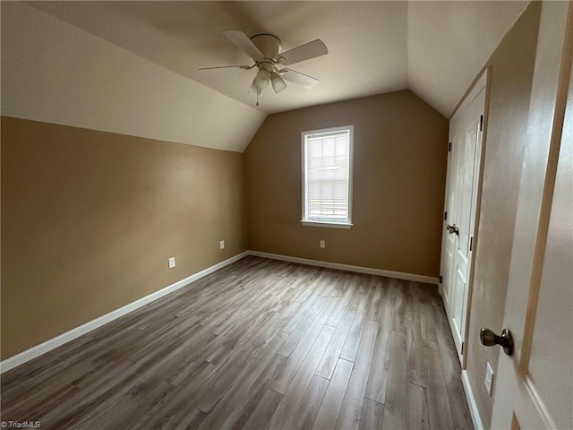 additional living space featuring hardwood / wood-style floors, vaulted ceiling, and ceiling fan