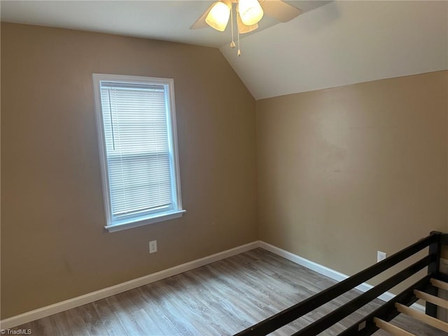 bonus room featuring light wood-type flooring, ceiling fan, vaulted ceiling, and a wealth of natural light