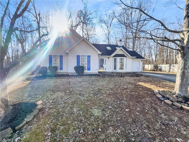 single story home featuring driveway, a chimney, an attached garage, and fence