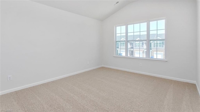 carpeted spare room featuring lofted ceiling