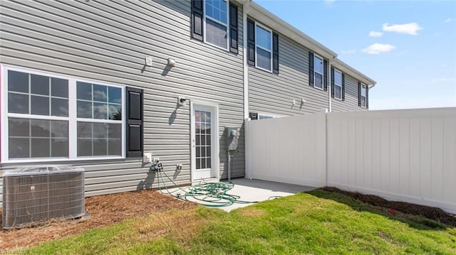 back of property with a yard and central AC unit