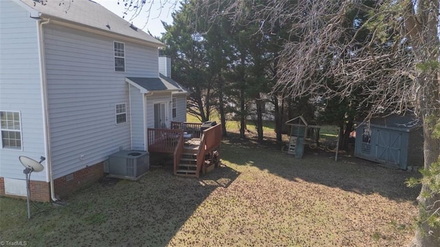 view of yard featuring central air condition unit, a storage unit, an outdoor structure, and a wooden deck