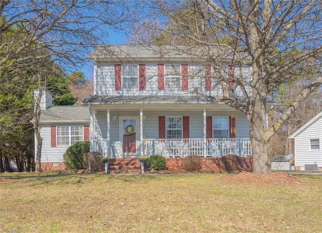 colonial home featuring covered porch, crawl space, a front yard, and a chimney