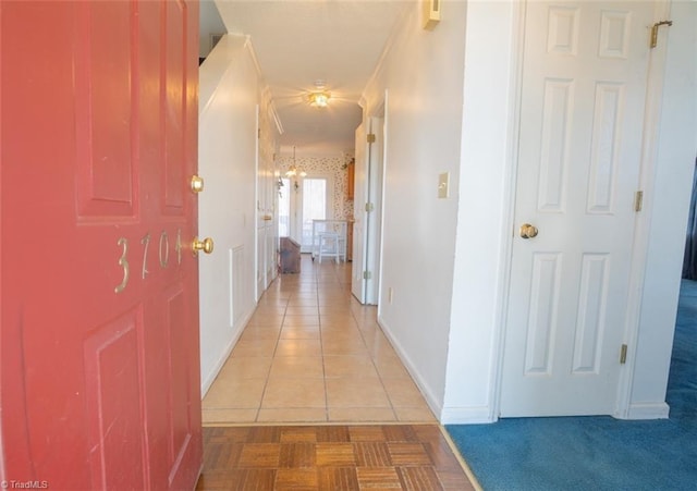 corridor featuring light tile patterned floors, light carpet, and baseboards