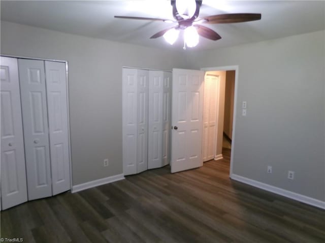 1074 Hickory Glen Rd, Winston-Salem, NC 27106 - unfurnished bedroom with two closets, wood finished floors, baseboards, and a ceiling fan