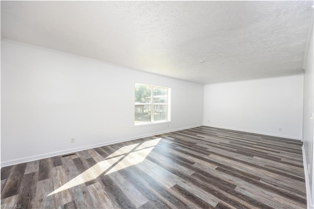 unfurnished room featuring a textured ceiling and dark hardwood / wood-style flooring