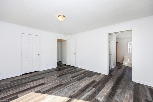 unfurnished bedroom featuring ornamental molding, dark hardwood / wood-style floors, and ensuite bathroom