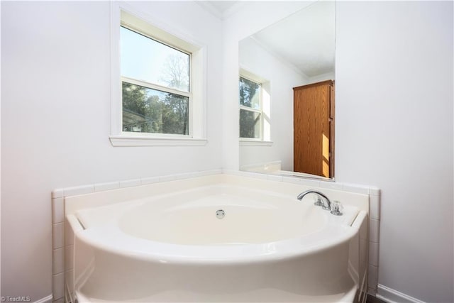 bathroom featuring a tub to relax in and crown molding