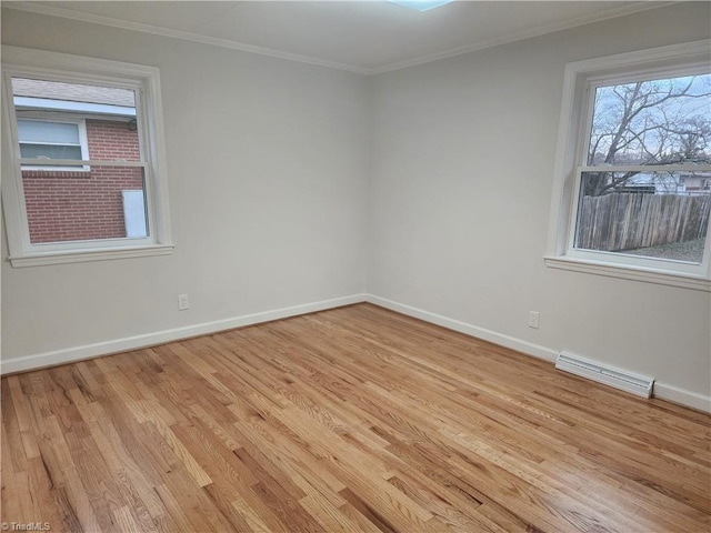 spare room with baseboards, light wood-style flooring, visible vents, and crown molding