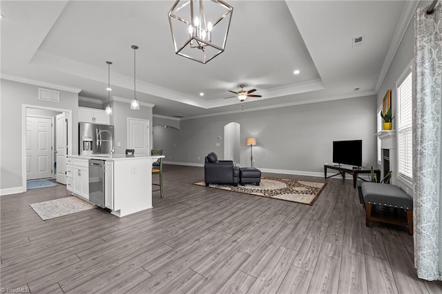 6624 Knob Creek Dr, Whitsett, NC 27377 - living area featuring a tray ceiling, baseboards, wood finished floors, recessed lighting, and ornamental molding
