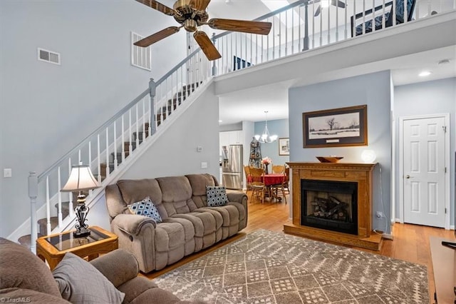 3702 Belfry Ct, Greensboro, NC 27410 - living area with stairs, a high ceiling, ceiling fan, wood finished floors, and a chandelier